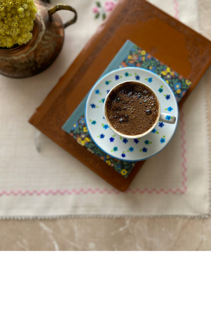 a cup of coffee sitting on a leather bound book 