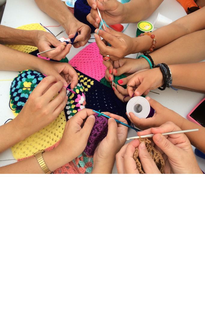 hands in a circle crocheting different projects