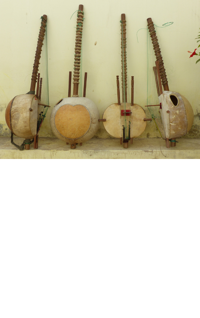 4 african kora instruments lined up against a wall for photograph