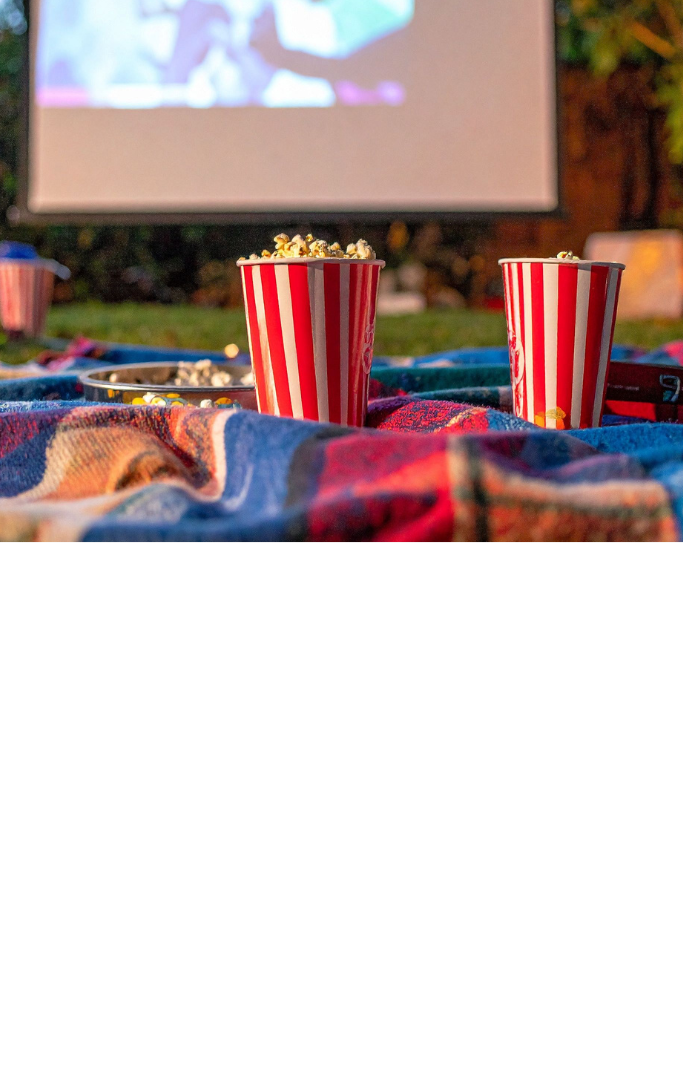 outdoor screen with a blanket and popcorn in front of it