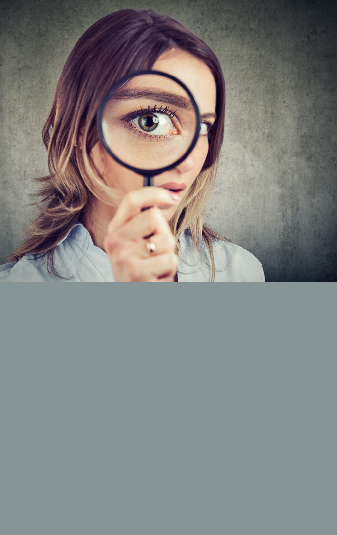 woman holding comically large magnifying glass